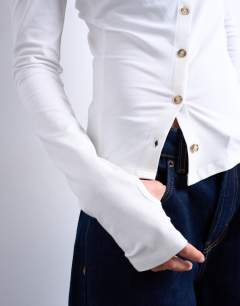Model wearing Asymmetric button through long sleeve top in ivory