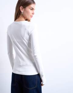 Model wearing Asymmetric button through long sleeve top in ivory
