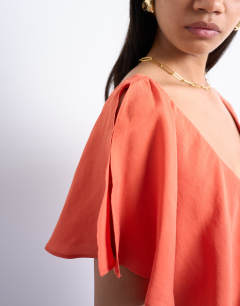 Model wearing Asymmetric frill mini dress in orange