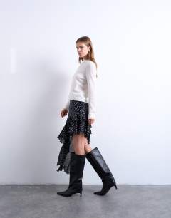 Model wearing Asymmetric hem frill detail midi skirt in black and white polka dot