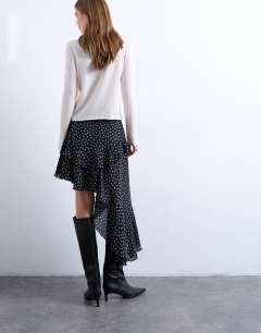 Model wearing Asymmetric hem frill detail midi skirt in black and white polka dot