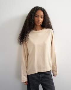 Model wearing Asymmetric hem raglan sleeve skater t-shirt in ecru