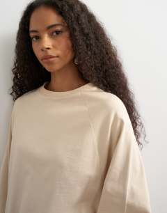 Model wearing Asymmetric hem raglan sleeve skater t-shirt in ecru