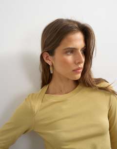 Model wearing Asymmetric long sleeve t-shirt in mustard
