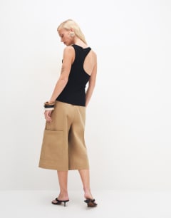 Model wearing Asymmetric racer back vest in black