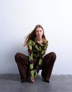 Model wearing Asymmetric slash neck floral print long sleeve top in green and brown