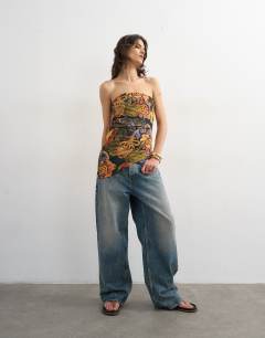 Model wearing Asymmetric twist bandeau in tropical print