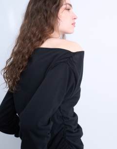 Model wearing Asymmetrical jersey slash neck long sleeve top in black