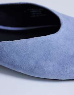 Model wearing Atlas mule flat shoe in blue