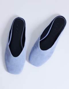 Model wearing Atlas mule flat shoe in blue