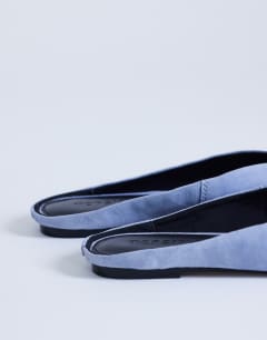 Model wearing Atlas mule flat shoe in blue