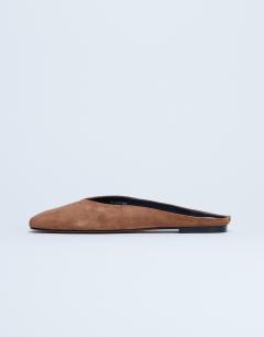 Model wearing Atlas mule flat shoe in tan