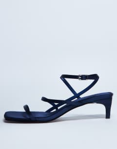 Model wearing Autumn minimal mid heel sandal in navy satin