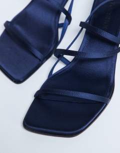 Model wearing Autumn minimal mid heel sandal in navy satin