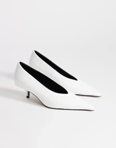 Model wearing Avril kitten heel mid court shoe in white