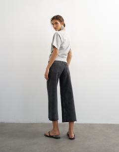 Model wearing Awkward crop jean in washed black
