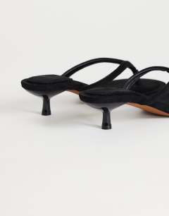 Model wearing Axel toe thong mid heel sandal in black faux suede 