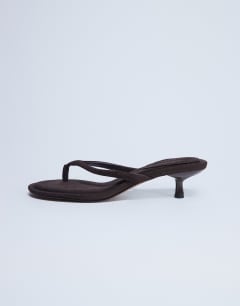 Model wearing Axel toe thong mid heel sandal in brown