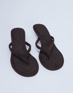 Model wearing Axel toe thong mid heel sandal in brown