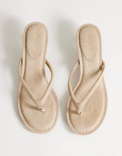 Model wearing Axel toe thong mid heel sandal in camel