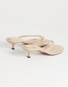 Model wearing Axel toe thong mid heel sandal in camel