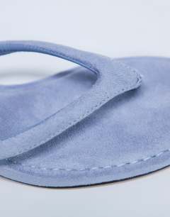 Model wearing Axel toe thong mid heel sandal in cornflower blue