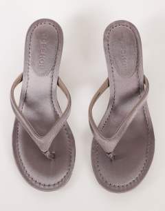 Model wearing Axel toe thong mid heel sandal in grey satin