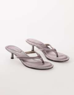 Model wearing Axel toe thong mid heel sandal in grey satin
