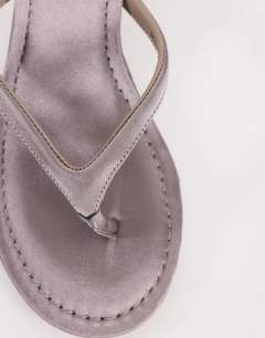 Model wearing Axel toe thong mid heel sandal in grey satin