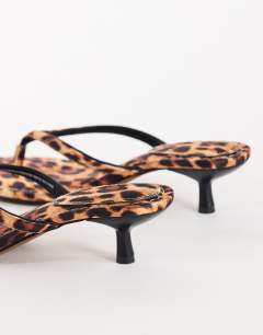 Model wearing Axel toe thong mid heel sandal in leopard print satin