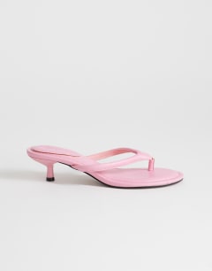 Model wearing Axel toe thong mid heel sandal in pink