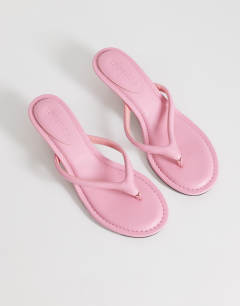 Model wearing Axel toe thong mid heel sandal in pink