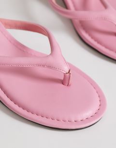Model wearing Axel toe thong mid heel sandal in pink