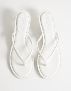 Model wearing Axel toe thong mid heel sandal in white