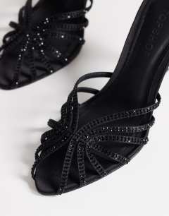 Model wearing Azelia heeled sandal  with gems in black satin