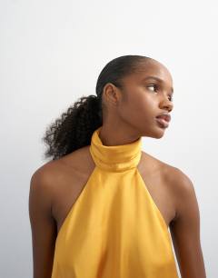 Model wearing Backless high neck halter top in yellow