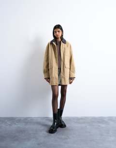 Model wearing Barn jacket with buckle detail in tan