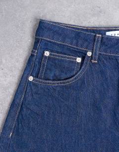 Model wearing Barrel high rise jean circular design in indigo rinse