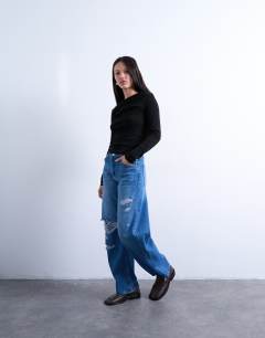 Model wearing Barrel jean with thigh rips in vintage blue