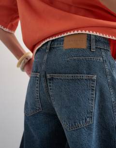 Model wearing Barrel jort in blue black