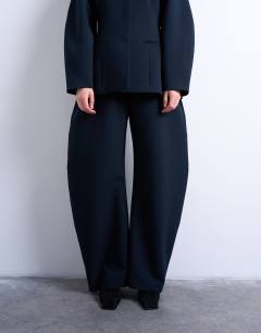 Model wearing Barrel leg tailored trousers in navy