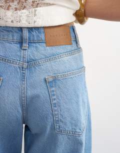 Model wearing Barrel mid rise jean in bleach