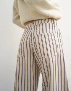 Model wearing Barrel mid rise jean in blue and natural stripe