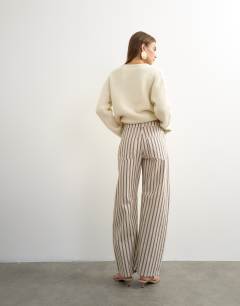 Model wearing Barrel mid rise jean in blue and natural stripe