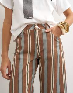 Model wearing Barrel mid rise jean in brown and blue stripe
