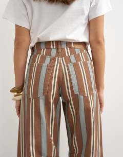 Model wearing Barrel mid rise jean in brown and blue stripe