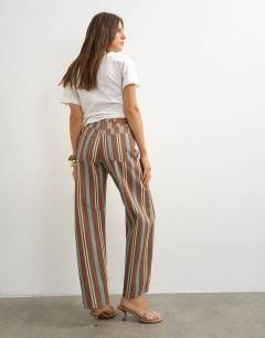 Model wearing Barrel mid rise jean in brown and blue stripe