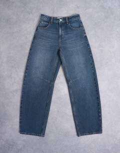 Model wearing Barrel mid rise jean in deep blue