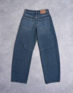 Model wearing Barrel mid rise jean in deep blue