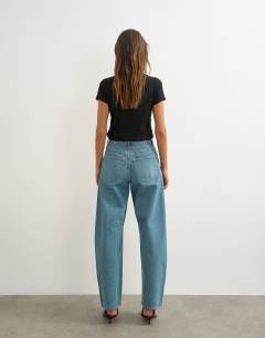 Model wearing Barrel mid rise jean in green cast